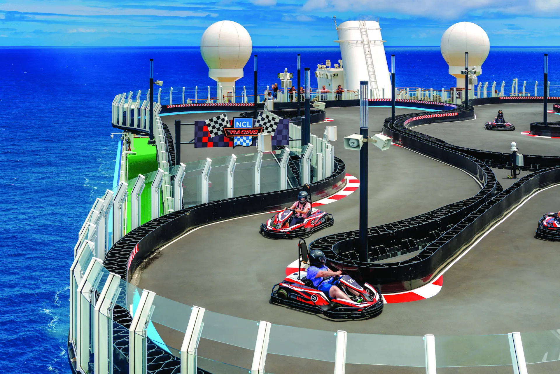De kartbaan op het bovenste dek van de Norwegian Bliss, met elektrische karts die rijden langs een circuit met uitzicht op zee.