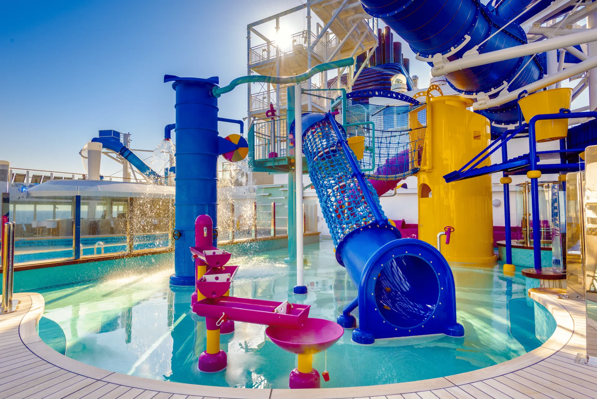 Het kleurrijke Kids Aqua Park aan boord van de Norwegian Bliss, met glijbanen, waterspeeltoestellen en een zonnig dek.