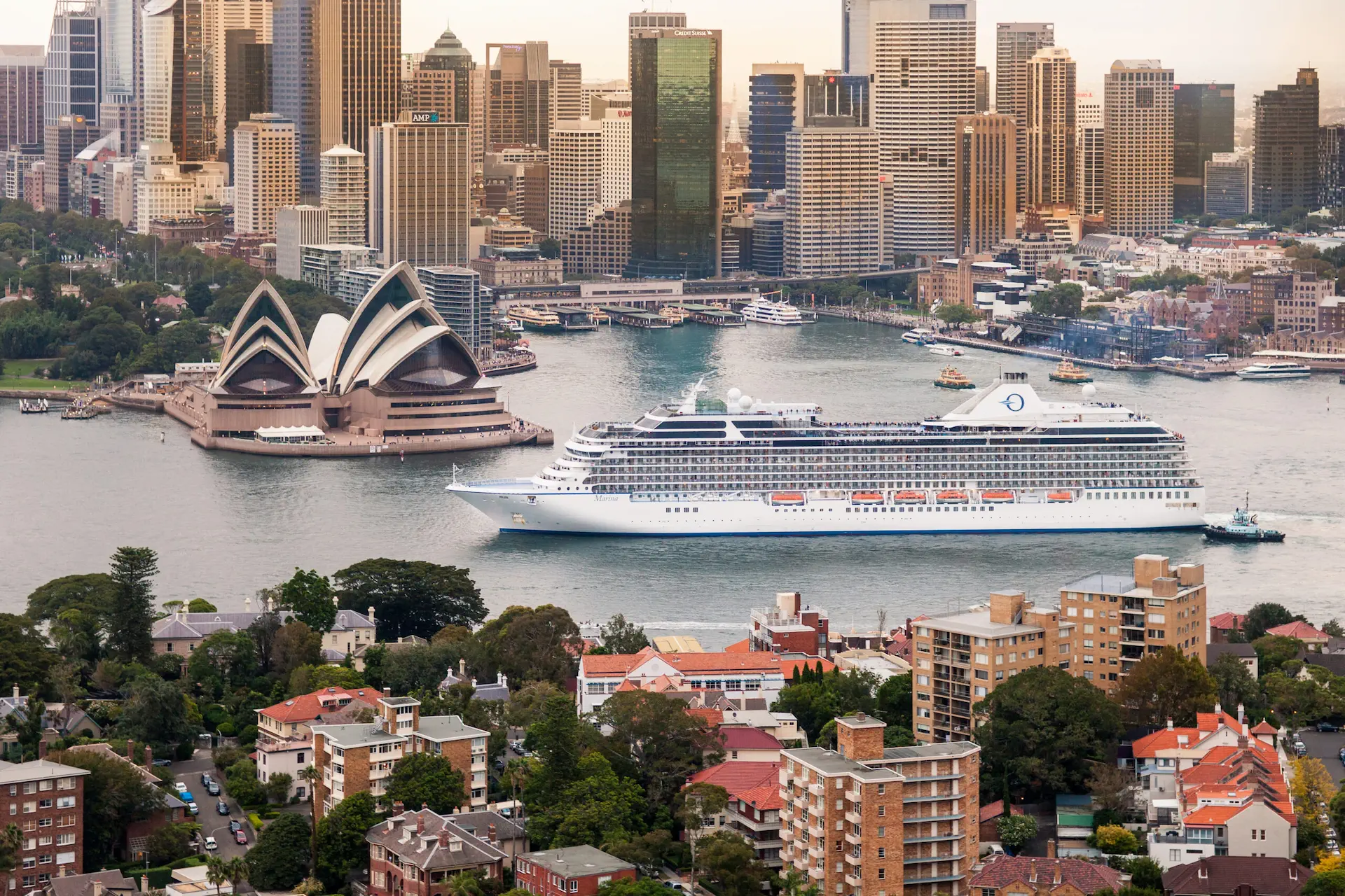 Het cruiseschip Marina vaart door Sydney Harbour met de skyline en het Sydney Opera House op de achtergrond.