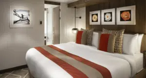 Slaapkamer van de Celebrity Suite op de Celebrity Ascent met kingsize bed