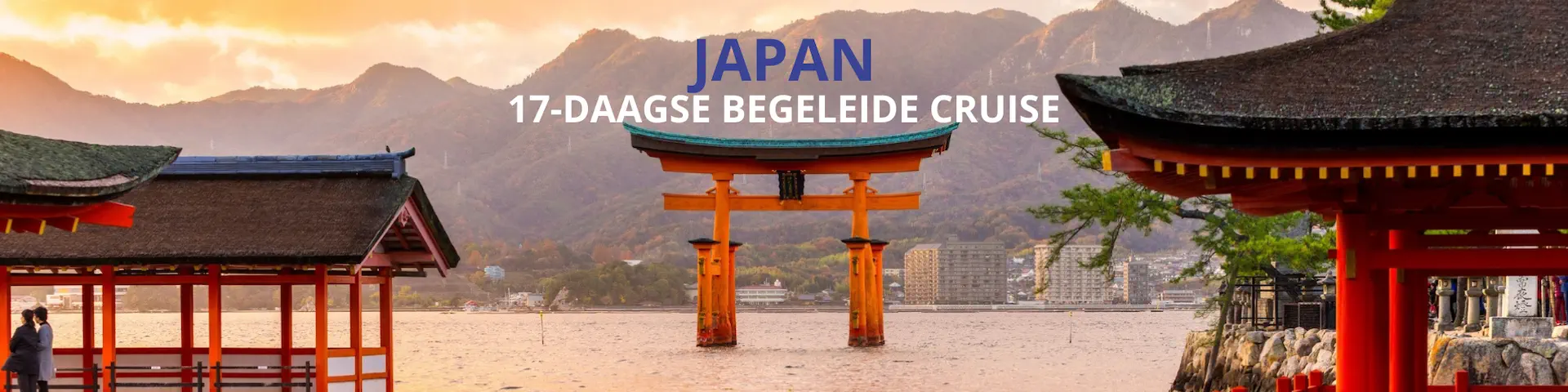 Torii-poort aan het water in Japan met traditionele gebouwen en bergen op de achtergrond.
