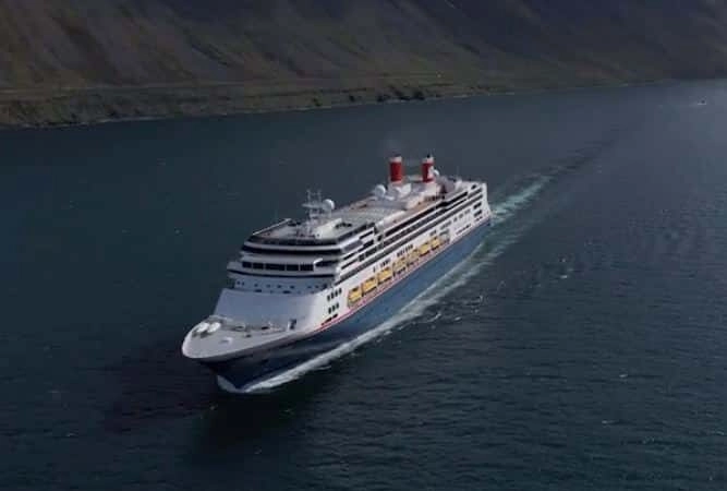 Cruiseschip Borealis van Fred Olsen dat vaart over zee langs een bergachtige kust