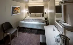 Modern interieur van de World Atlantic Deluxe Binnenhut IR met een groot tweepersoonsbed, bureau en sfeervolle wanddecoratie.