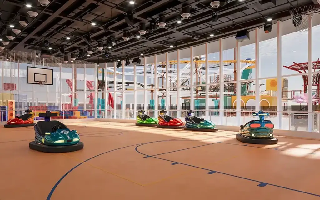 Interieur van de Clubhouse op de MSC World Atlantic met botsauto's op een sportveld, basketbalring en uitzicht op een pretpark buiten.