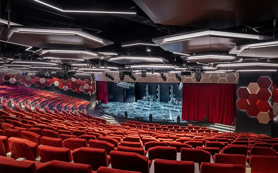 Theaterzaal aan boord van MSC World Asia met zitplaatsen en podium voor live shows